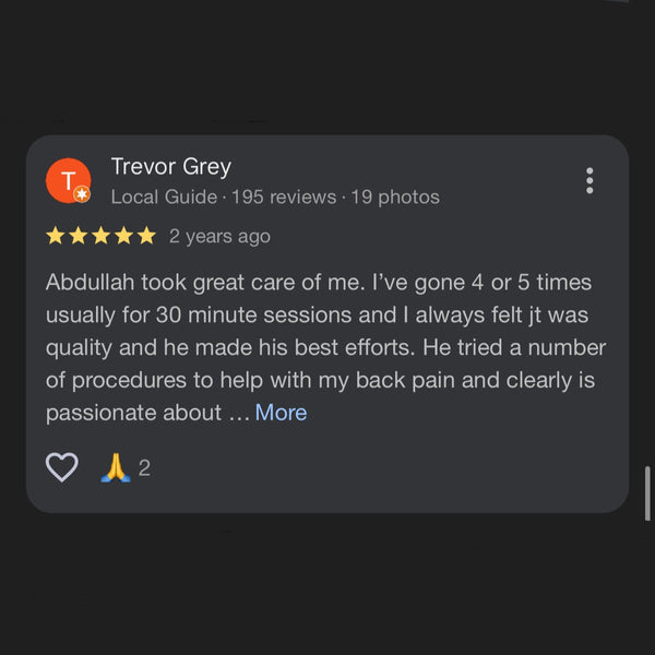 Customer review and response on a massage center's platform with a dark background.